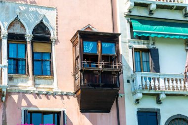 Venedik, Veneto - İtalya - 06-10-2021: Palazzo Barbarigo Minotto 'nun süslü Venedik mimarisi ahşap panjurlar ve çiçekli balkon