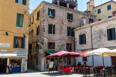 Venedik, Veneto - İtalya - 06-09-2021: Güneşli bir günde Venedik meydanında şemsiyeli antika bir kafe