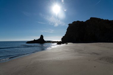 Cabo de Gata, Almeria - Spain - 01-23-2024: Sunlit view of the sandy beach of Media Luna with its iconic volcanic rocks, Cabo de Gata, Spain clipart