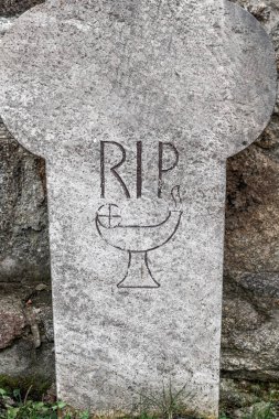 Bautzen, Saksonya - Almanya - 04-10-2021: 'RIP' li yaşlandırılmış mezar taşı ve basit kadeh çizimi, anıları sembolize ediyor