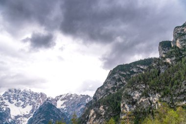 Alpen, Güney Tyrol - İtalya - 06-07-2021: Alplerdeki kısmen karla kaplı dağ zirvelerinde beliren kara bulutlar dramatik bir sahne yaratıyor