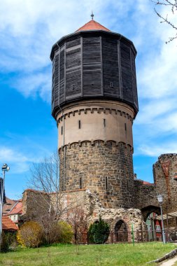 Bautzen, Saksonya - Almanya - 04-10-2021: Bautzen 'de harabeler ve yeşilliklerin ortasında yer alan taş duvarcılık ve kereste çerçevelerinin bir karışımının yer aldığı ortaçağ su kulesi