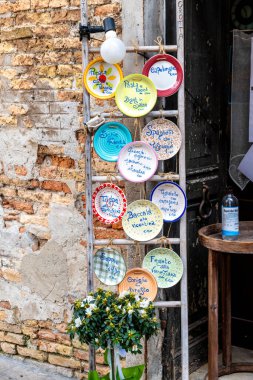 Treviso, Venetien - İtalya - 06-08-2021: Geleneksel İtalyan yemekleri ve bunların fiyatları küçük Osteria Alla Grotta restoranının kırsal duvarında yer alan renkli tabaklar