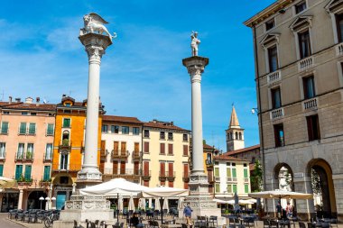Vicenza, Venetien - İtalya - 06-12-2021: Vicenza, İtalya 'da Piazza dei Signori, Kurtarıcı ve Venedik Aslanı ile birlikte tarihi binaları, hareketli pazarları ve davetkar restoranları olan iki sütunla