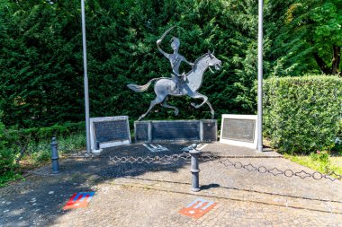 Treviso, Venetien - İtalya - 06-13-2021: Treviso 'da çevreleyen yeşil çitlerle çevrili bir anıtta, bilgilendirici plaklarla birlikte metal binicilik heykeli