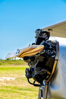 Caorle, Venetien - İtalya - 06-14-2021: Radyal motorun ayrıntılı görüntüsü ve temiz bir gökyüzüne karşı klasik bir uçağın ahşap pervanesi