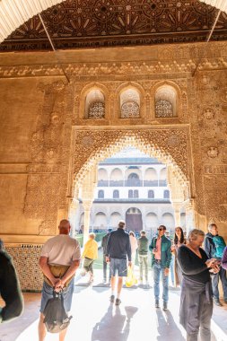 Granada, Granada - Spain - 01-30-2024: Visitors admire intricate Moorish carvings in the sunlit Nasrid Palaces, the historic jewel of the Alhambra clipart