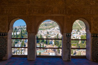 Granada, Granada - İspanya - 01-30-2024: Granada ikonik beyaz evleri ve selvi ağaçları ile El Partal 'ın süslü kemerlerinden Albaisin' e bakın