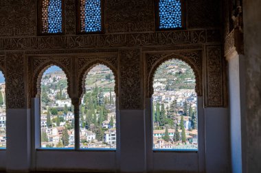Granada, Granada - İspanya - 01-30-2024: Karmaşık dekore edilmiş Fas kemerleri Granada 'nın Alhambra' dan nefes kesici manzarasını çerçeveler