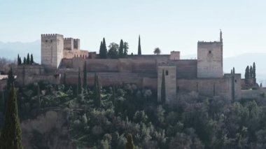 Granada, İspanya 'daki Alhambra manzarası, dışarıdan, bir tepe üzerinde birçok ağaçla çevrili ve biraz bulanık görülebilirliği var.