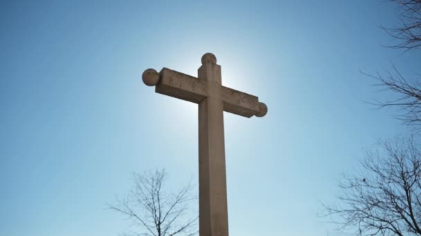 从下面看一个混凝土十字架 面朝蓝天 太阳在十字架后面对着相机 从后面看十字架 — 图库视频影像