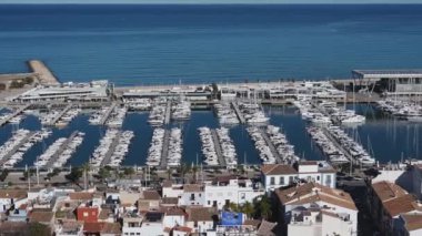 Denia, Alicante - İspanya 11-04-2023: Özel yatlar, yelkenliler ve büyük feribotların yer aldığı özel marinadan ticari limana kadar Denia limanının solundan sağa doğru süpürülüyor