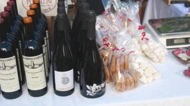 Denia, Alicante - İspanya 11-04-2023: Yerel ürünlerle pazar tezgahı üzerinde gezinme: peynir, sosis, şarap ve daha fazlası, kısmen ölçekli kırmızı-beyaz masa örtüsü üzerine.