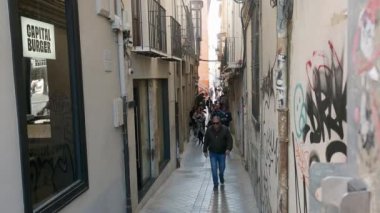 Granada, Granada - İspanya 02-03-2024: Turistler ve öğrenciler arasında popüler olan bir sokak kafesinin açık hava sahası, güneş ışığı ve bahar sıcaklığında kahve ve bira keyfine davet ediyor.