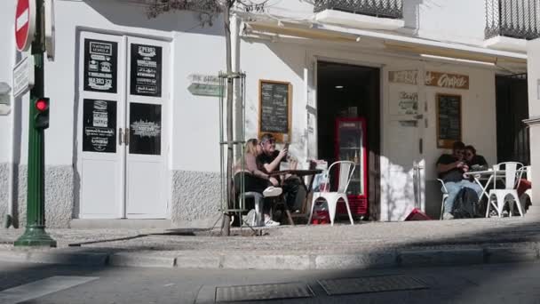 グラナダ グラナダ スペイン 2024 歩道に直接テーブルが付いている絵のように美しいストリートカフェで左から右にスローパン ウェイターがサービスし 若者が時間を過ごす場所 — ストック動画