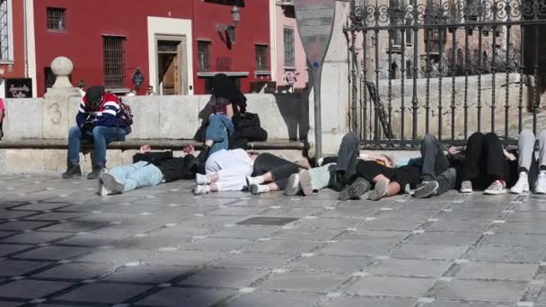 Многие Молодые Туристы Отдыхают Тротуаре Гранаде Испания Перед Забором Полдень — стоковое видео