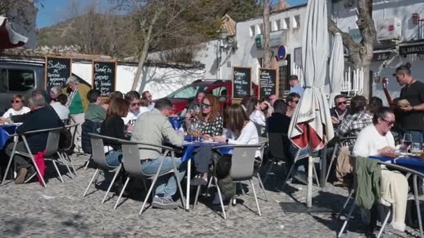 グラナダ グラナダ スペイン 2024 プラスチック製の椅子と青いテーブルクロスのグラナダで賑やかなレストランの屋外エリア 床が舗装され 太陽が輝いている — ストック動画