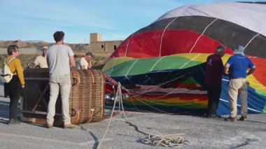 Guadix, Granada - İspanya 01-25-2024: Sıcak hava balonunun şişirilmesi: Sıcak hava açıklığa üflenerek balonun genişlemesine neden olur. Sepet yana yatıyor..