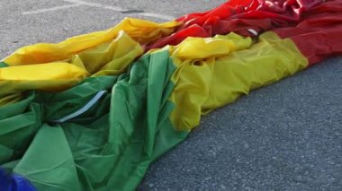 Kamera uzun, parlak katlanmış sıcak hava balonu boyunca asfalt yüzeyde dinleniyor.