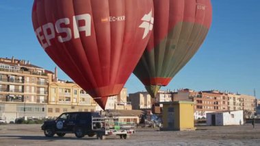 Guadix, Granada - İspanya 01-25-2024: Şehir manzarasına karşı şişirilmiş iki sıcak hava balonu, biri yükselen, yakından konumlanmış, dokunaklı.