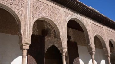 Granada, Granada - İspanya 01-27-2024: Suyun güzelce yansıttığı sütunları, ışığı ve gölgesi olan bir Alhambra binasının ince işçilikli cephesi.
