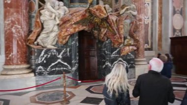 Roma, Latium - İtalya 11-22-2022: Roma 'daki Aziz Peter Bazilikası' nın özel bir girişinden büyük katedralde çok sayıda ziyaretçinin bulunduğu küçük bir sunağa kamera yansıması.