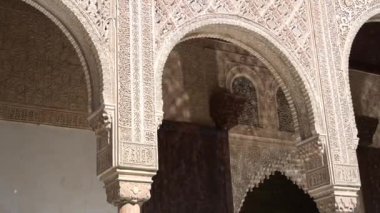 Granada, Granada - İspanya 01-27-2024: Suyun güzelce yansıttığı sütunları, ışığı ve gölgesi olan bir Alhambra binasının ince işçilikli cephesi.