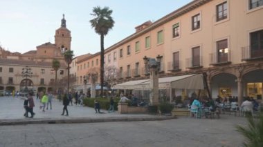 Guadix, Granada - İspanya - 01-24-2024: Guadix 'te çocukların oynadığı, oturma alanlarının insanları dinlenmeye ve hareketli sosyal hayat nabızlarına davet ettiği evlerle dolu bir meydanın üzerindeki bir tava