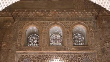 Granada, Granada - İspanya - 01-27-2024: Alhambra 'daki bir salonun süslü görünüşü. Güneş ışığı pencerelerden akar ve etkileyici bir gölgeler oyunu yaratır.
