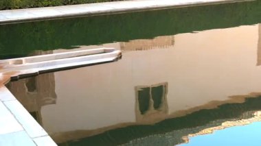 Granada, Granada - İspanya - 01-27-2024: Alhambra 'nın avlusundaki havzanın karşısında soldan sağa doğru kaynayan bir çeşme var. Havza mermer ve taşla süslü çerçevelenmiş..