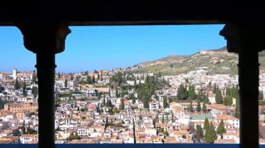 Granada, Granada - İspanya - 01-27-2024: Alhambra 'nın balkonundan bir korkuluk ve iki sütun boyunca Granada üzerinde mavi gökyüzü altında, arka planda yumuşak bir dağ, arka planda