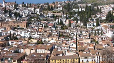 Granada, Granada - İspanya - 01-27-2024: Pan Alhambra 'dan Granada' nın güneşli evlerine, resim gibi tepenin üzerinde uzanan, mavi gökyüzü ise manzarayı mükemmel bir şekilde çerçeveler.