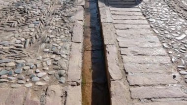 Granada, Granada - İspanya 01-27-2024: Kenarları çeşitli kaldırım taşlarıyla kaplı olan Alhambra 'daki su kanalının bir görüntüsü, su yavaşça akarken,