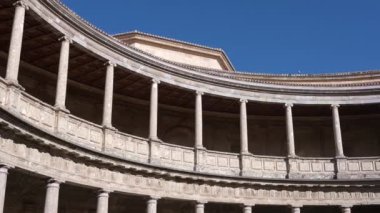 Granada, Granada - İspanya - 01-27-2024: Charles V Sarayı 'nın avlusunda bir tava, üst katta, aralıklı sütunların avluyu çerçevelediği yerde. Avlunun bazı kısımları gün ışığında parlıyor