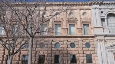 Granada, Granada - İspanya - 01-27-2024: Charles V Sarayı cephesinde geniş, simetrik taşlardan yapılmış bir tava. Merkezde heybetli, kapalı bir giriş kapısı var.