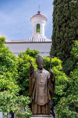 Beyaz bir masa örtüsü, beyaz tabaklar, çatal bıçak takımı ve rulo peçete ile kaplı bir masanın üzerinde şık bir masa düzenlenir.