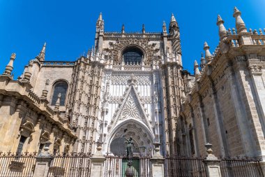 Beyaz bir masa örtüsü, beyaz tabaklar, çatal bıçak takımı ve rulo peçete ile kaplı bir masanın üzerinde şık bir masa düzenlenir.