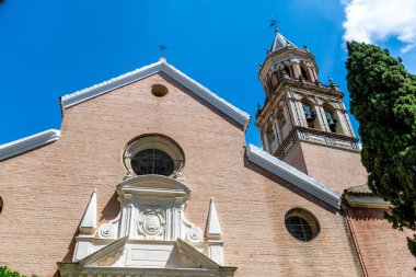 Beyaz bir masa örtüsü, beyaz tabaklar, çatal bıçak takımı ve rulo peçete ile kaplı bir masanın üzerinde şık bir masa düzenlenir.