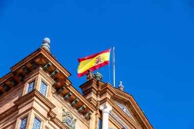 Beyaz bir masa örtüsü, beyaz tabaklar, çatal bıçak takımı ve rulo peçete ile kaplı bir masanın üzerinde şık bir masa düzenlenir.