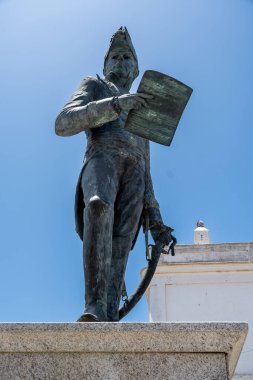 Beyaz bir masa örtüsü, beyaz tabaklar, çatal bıçak takımı ve rulo peçete ile kaplı bir masanın üzerinde şık bir masa düzenlenir.