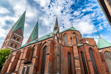 Beyaz bir masa örtüsü, beyaz tabaklar, çatal bıçak takımı ve rulo peçete ile kaplı bir masanın üzerinde şık bir masa düzenlenir.