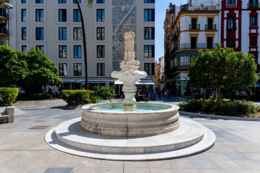 Sevilla, Sevilla - İspanya 04-19-2024: Plaza del Cabildo 'dan mağazalar, sütunlar ve bitkilerle dolu bir geçit. Sanatsal olarak boyanmış bir kemer yaklaşık 50 metre uzunluğundaki geçidi süslüyor.