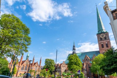 La Linea, Cadiz - İspanya 06-03-2024: Arka planda gökdelenler ve dağlarla sahil yolunda bir adam oturuyor.