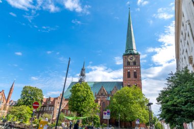 La Linea, Cadiz - İspanya 06-03-2024: Arka planda gökdelenler ve dağlarla sahil yolunda bir adam oturuyor.