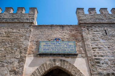 La Linea, Cadiz - İspanya 06-03-2024: Arka planda gökdelenler ve dağlarla sahil yolunda bir adam oturuyor.