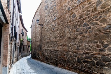 La Linea, Cadiz - İspanya 06-03-2024: Arka planda gökdelenler ve dağlarla sahil yolunda bir adam oturuyor.