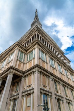 La Linea, Cadiz - İspanya 06-03-2024: Arka planda gökdelenler ve dağlarla sahil yolunda bir adam oturuyor.
