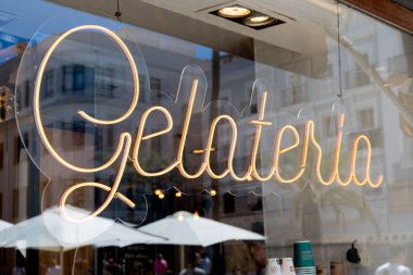 Cadiz, Cadiz - İspanya - 05-06-2024: Bir kafenin önündeki parlak neon rengi tabela, çevrenin yaz atmosferini yansıtıyor.