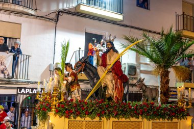 Castro del Rio, Cordoba - İspanya - 03-24-2024: Semana Santa 'da bir Paskalya alayında eşeğin üzerinde İsa ile birlikte dini geçit töreni.