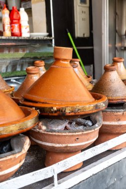 Agadir, Souss-Massa - Fas - 07-31-2024: Fas 'ta yavaş pişirilen ağır ateşte kullanılan kömür ocağındaki tagine kaplarının yakın çekimi.
